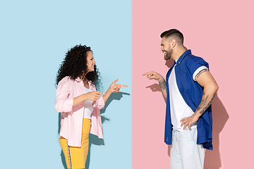 Image showing Young emotional man and woman on pink and blue background