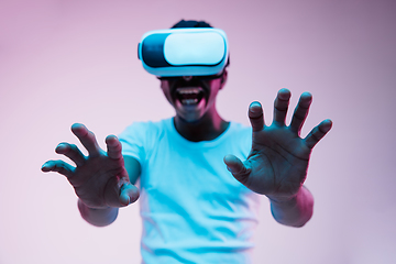 Image showing Young african-american man\'s using VR-glasses in neon light