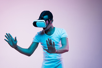 Image showing Young african-american man\'s using VR-glasses in neon light