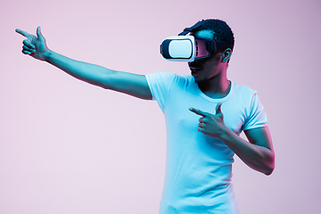 Image showing Young african-american man\'s using VR-glasses in neon light