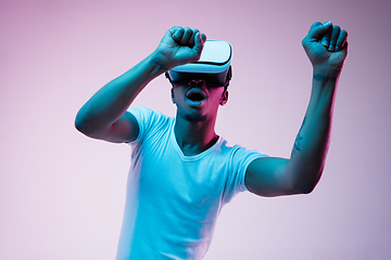 Image showing Young african-american man\'s using VR-glasses in neon light