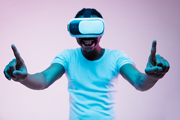 Image showing Young african-american man\'s using VR-glasses in neon light