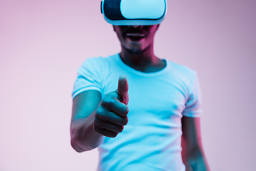 Image showing Young african-american man\'s using VR-glasses in neon light