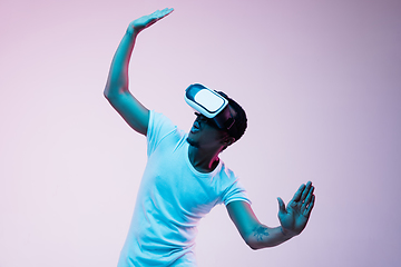 Image showing Young african-american man\'s using VR-glasses in neon light