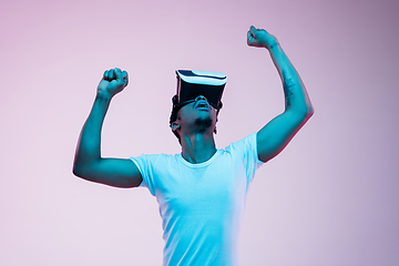 Image showing Young african-american man\'s using VR-glasses in neon light