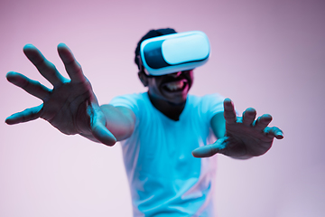 Image showing Young african-american man\'s using VR-glasses in neon light