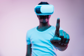 Image showing Young african-american man\'s using VR-glasses in neon light