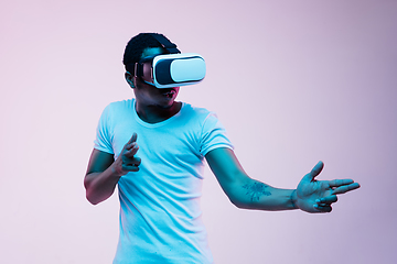 Image showing Young african-american man\'s using VR-glasses in neon light