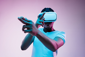 Image showing Young african-american man\'s using VR-glasses in neon light