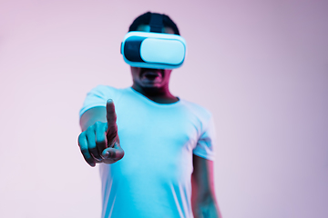 Image showing Young african-american man\'s using VR-glasses in neon light