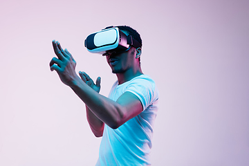 Image showing Young african-american man\'s using VR-glasses in neon light