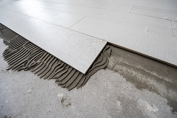 Image showing Ceramic wood effect tiles and tools for tiler on the floor