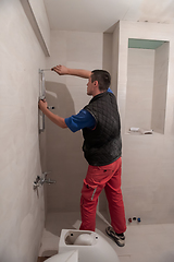 Image showing professional plumber working in a bathroom