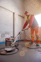 Image showing worker performing and polishing sand and cement screed floor