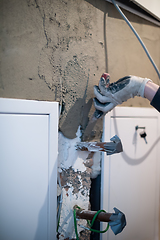 Image showing Worker plastering the wall by concrete