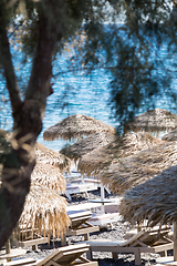 Image showing beach with umbrellas and deck chairs by the sea in Santorini