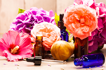 Image showing flowers and bottles of essential oils for aromatherapy