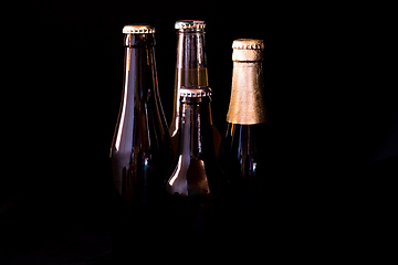 Image showing beer bottles on a black background in bright dark