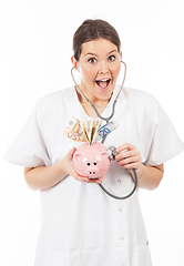 Image showing happy woman doctor with piggy bank full of money