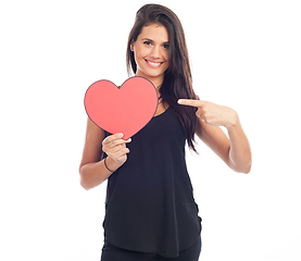 Image showing beautiful happy brunette woman holding and showing a big red hea