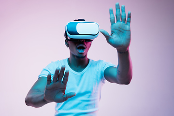 Image showing Young african-american man\'s using VR-glasses in neon light