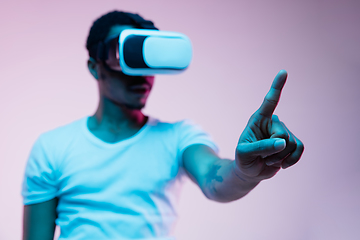 Image showing Young african-american man\'s using VR-glasses in neon light