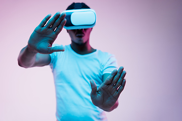 Image showing Young african-american man\'s using VR-glasses in neon light