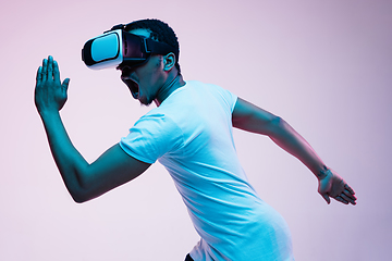 Image showing Young african-american man\'s using VR-glasses in neon light