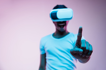 Image showing Young african-american man\'s using VR-glasses in neon light