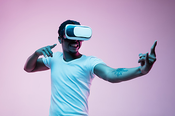 Image showing Young african-american man\'s using VR-glasses in neon light