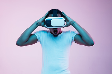 Image showing Young african-american man\'s using VR-glasses in neon light