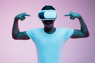 Image showing Young african-american man\'s using VR-glasses in neon light