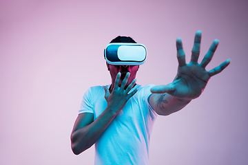 Image showing Young african-american man\'s using VR-glasses in neon light