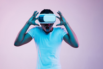 Image showing Young african-american man\'s using VR-glasses in neon light