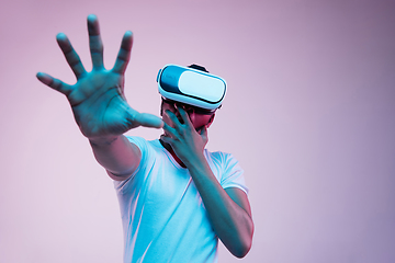 Image showing Young african-american man\'s using VR-glasses in neon light