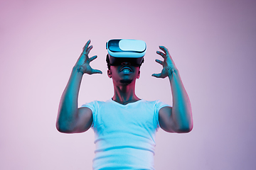 Image showing Young african-american man\'s using VR-glasses in neon light