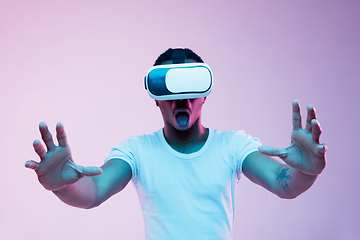 Image showing Young african-american man\'s using VR-glasses in neon light