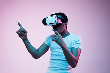 Image showing Young african-american man\'s using VR-glasses in neon light