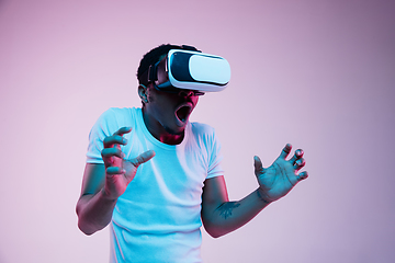 Image showing Young african-american man\'s using VR-glasses in neon light