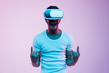 Image showing Young african-american man\'s using VR-glasses in neon light