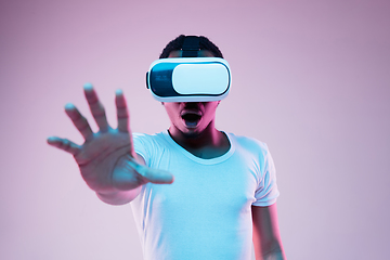 Image showing Young african-american man\'s using VR-glasses in neon light