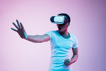 Image showing Young african-american man\'s using VR-glasses in neon light