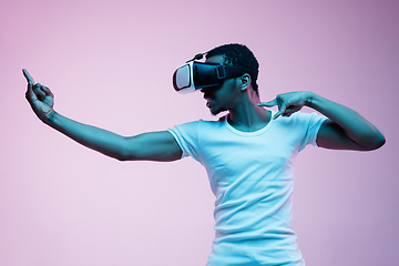 Image showing Young african-american man\'s using VR-glasses in neon light