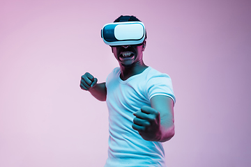 Image showing Young african-american man\'s using VR-glasses in neon light