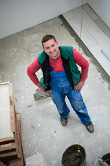 Image showing worker installing the ceramic wood effect tiles on the floor