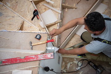 Image showing carpenter installing wooden stairs