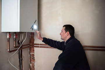 Image showing engineer checking technical data of heating system