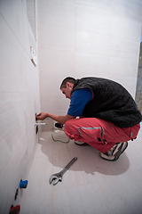 Image showing professional plumber working in a bathroom