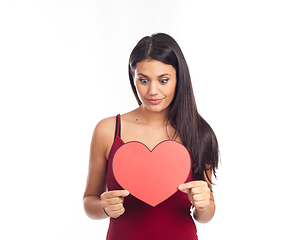 Image showing beautiful happy brunette woman holding and showing a big red hea