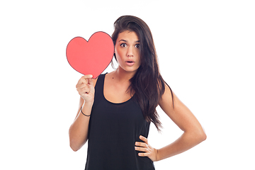 Image showing beautiful happy brunette woman holding and showing a big red hea